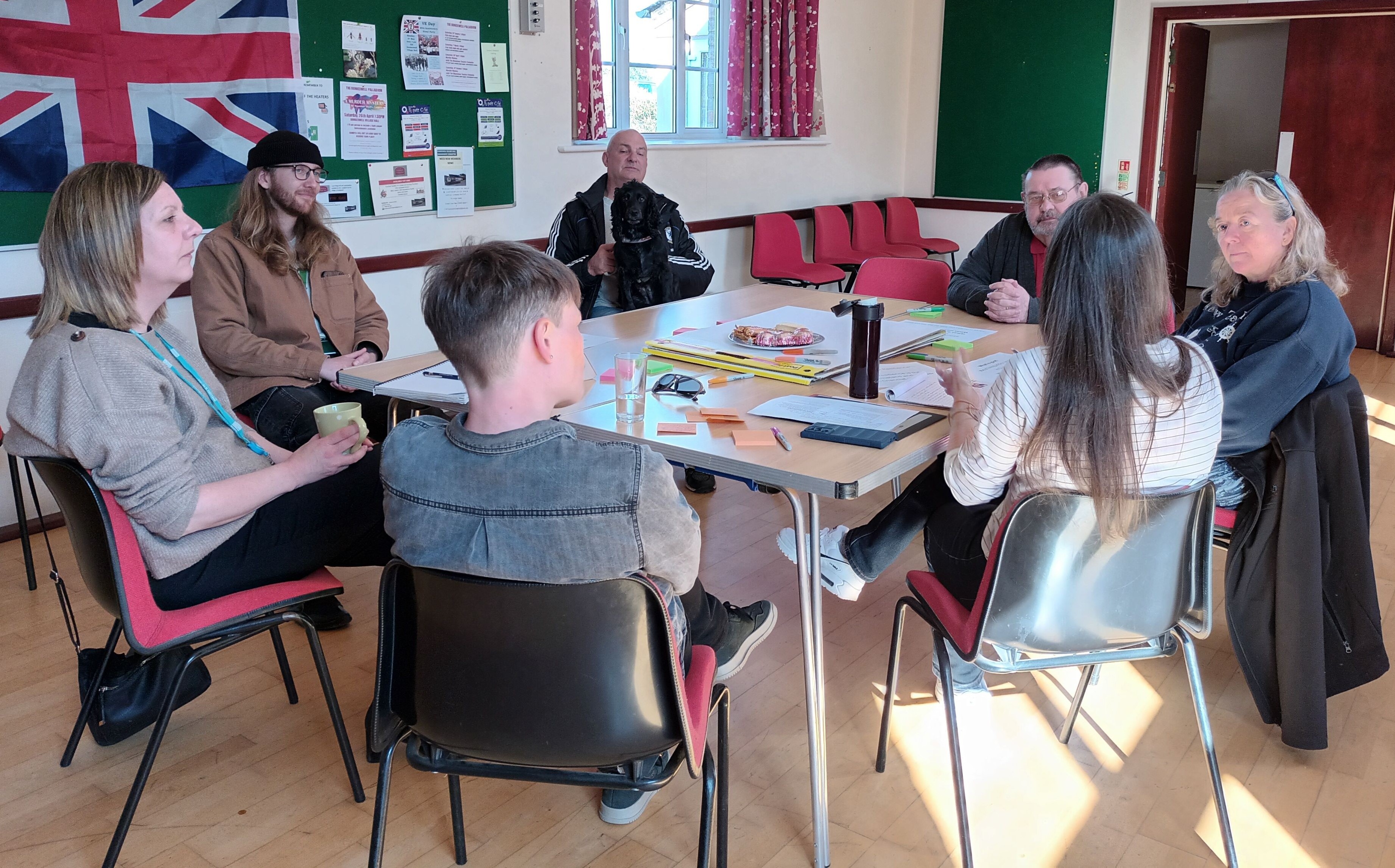 People sat around a table in a village hall