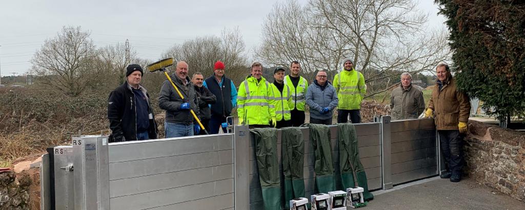 group of people stood near a flood defence