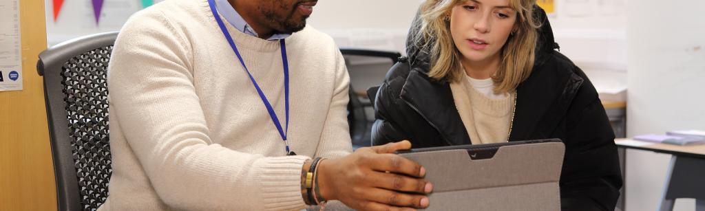 Adviser sitting with young female at a table with a laptop