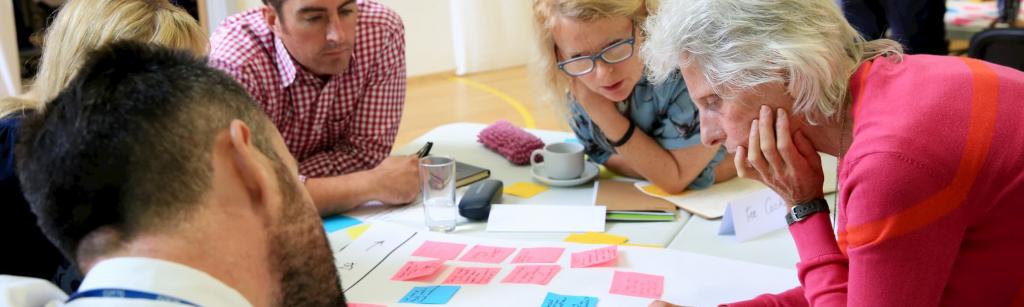 People overlooking a project board of sticky notes