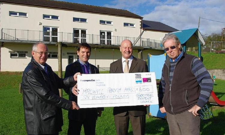 The photo shows Barry Parsons presenting a cheque for £600 towards new recycling bins that will be situated in the Parish hall car park.