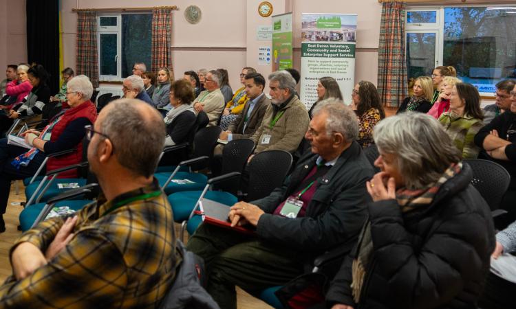 Group of people sitting in a village hall