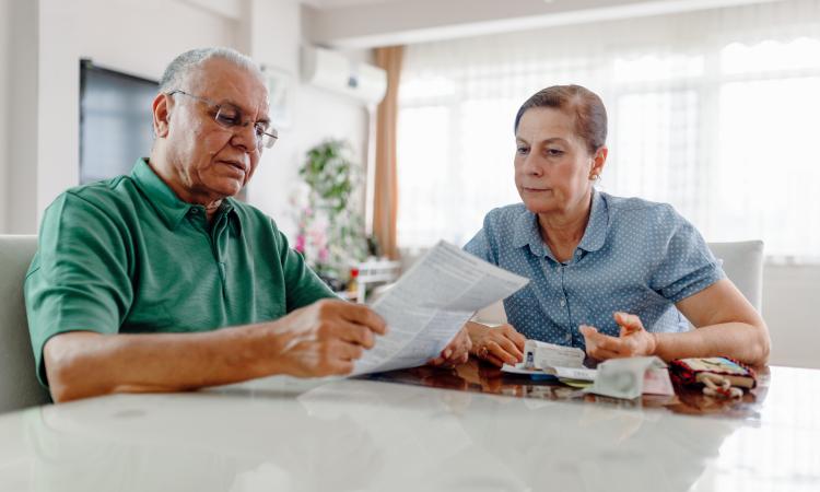 serious mature adults looking at post sitting at a table
