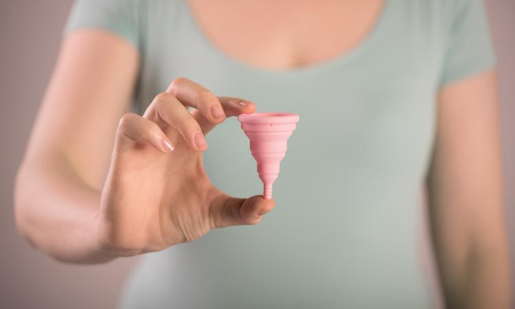 woman holding a moon cup