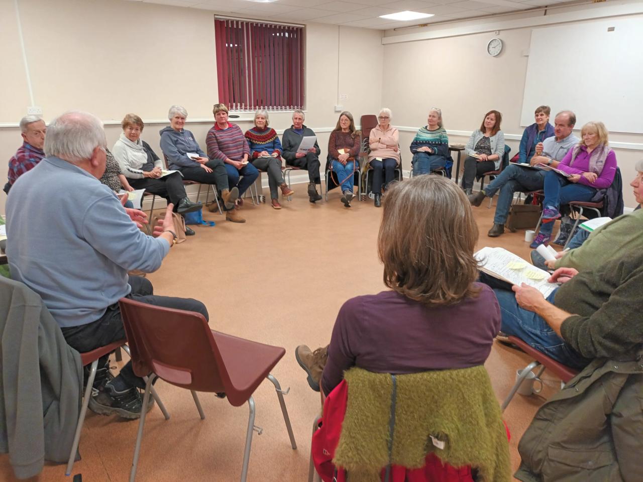 Mid Devon Village Hall Cluster - group of people sitting in a circle on chairs in a village hall
