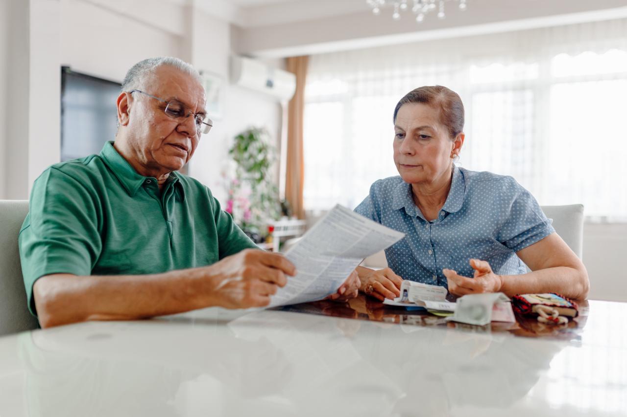 serious mature adults looking at post sitting at a table