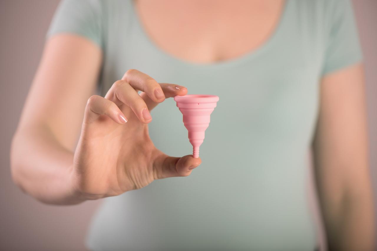 woman holding a moon cup